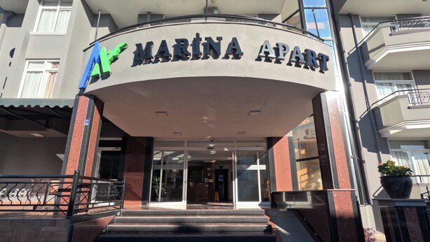 Entrada a Marina Apartments con vista clara de la entrada, escalones y una planta en maceta a la derecha.