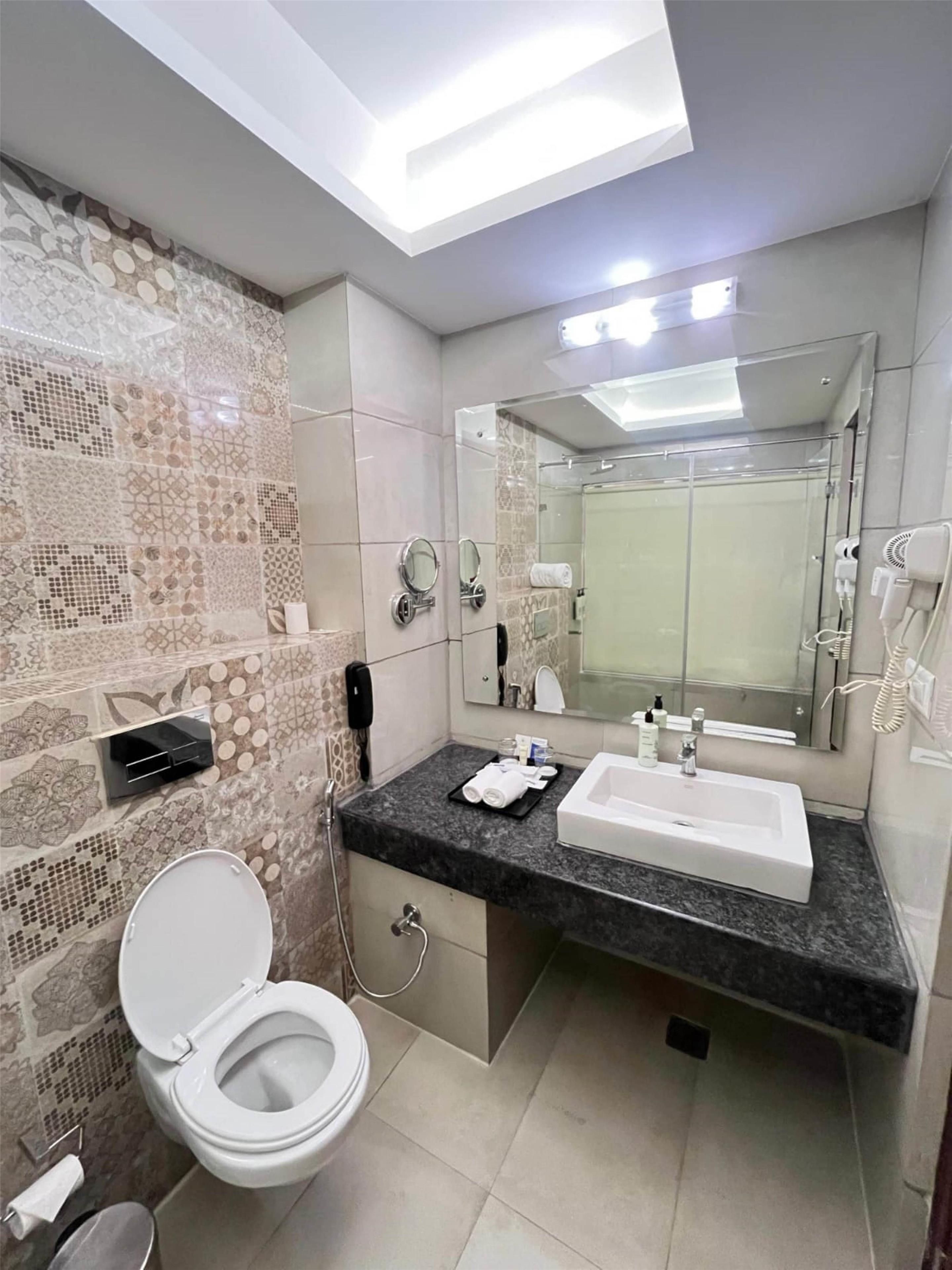 A modern bathroom with a toilet, sink, and shower area.