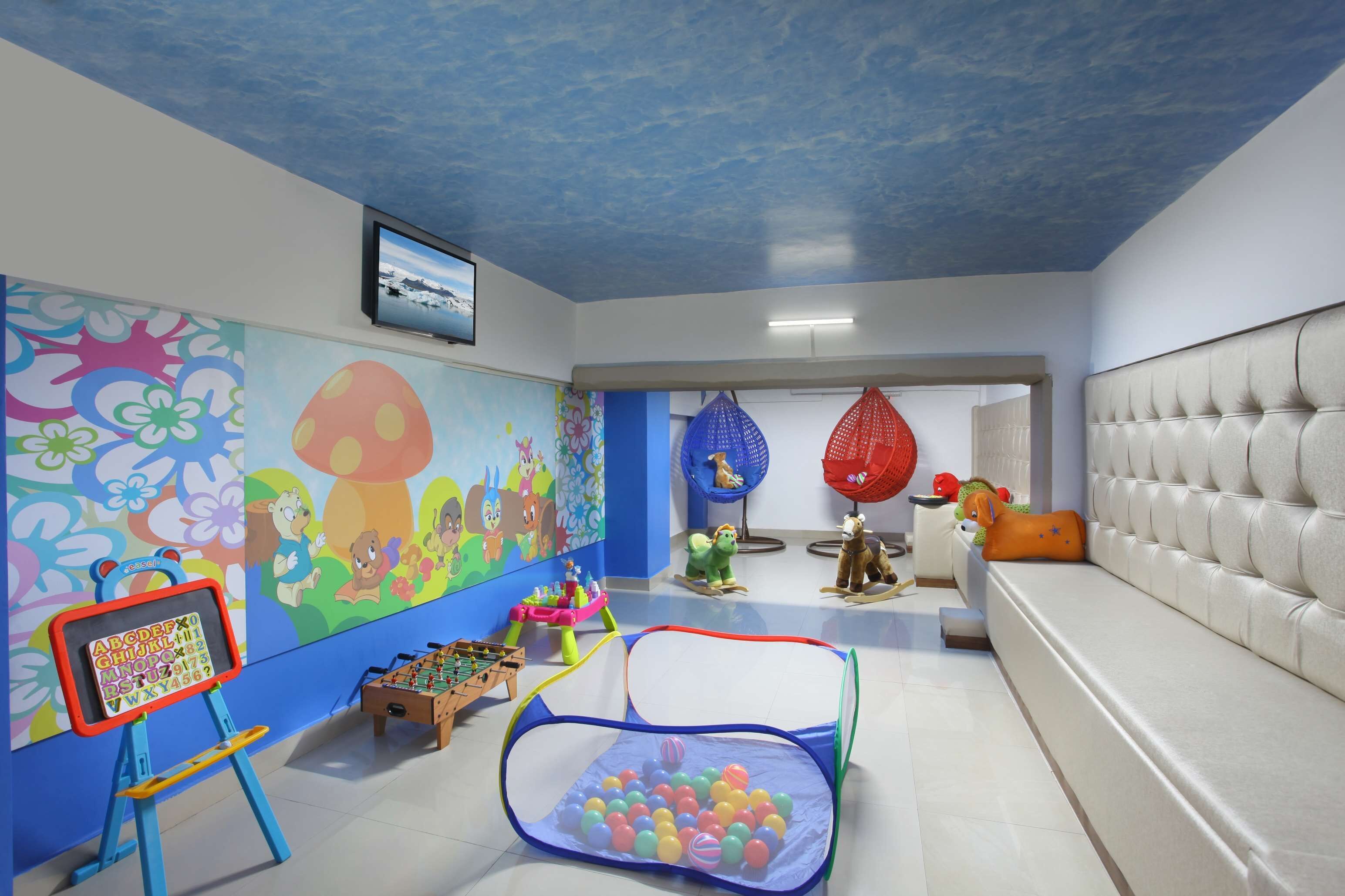 A children's play area with a ball pit, colorful murals, and a foosball table.