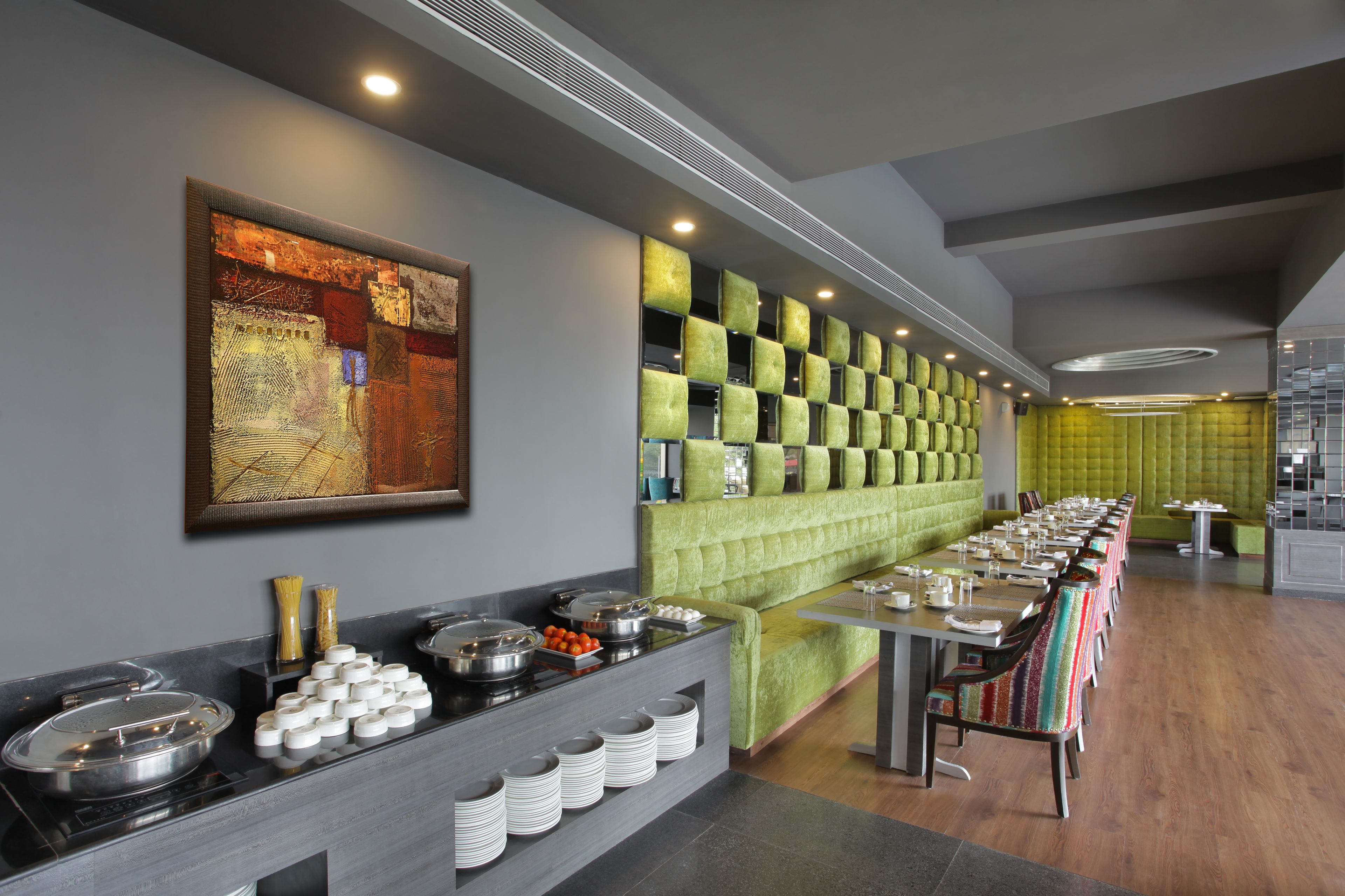 A buffet setup with a variety of food items, a long table, and a seating area with cushioned chairs.