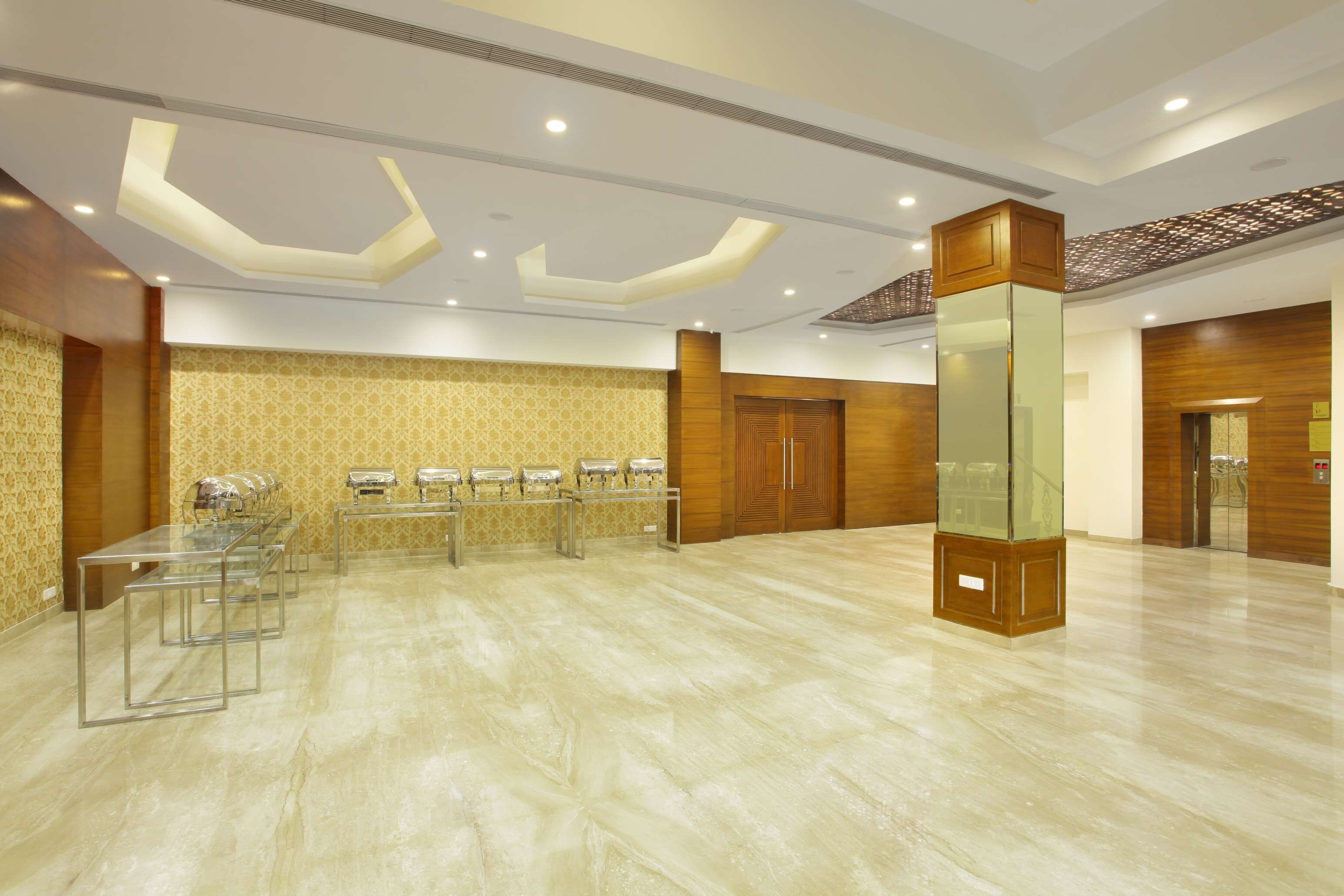 Un hall d’hôtel spacieux, doté d’un long comptoir d’accueil, de nombreuses caméras de surveillance et d’un design de plafond moderne.