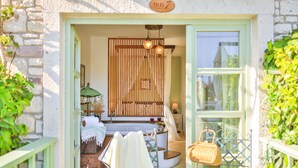Une pièce chaleureuse avec un mur lambrissé en bois, une petite baignoire et un fauteuil en osier.