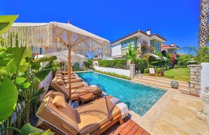 A pool with lounge chairs, a covered seating area, and a well-maintained garden. - Palas Alacati - Adults Only (Cesme)