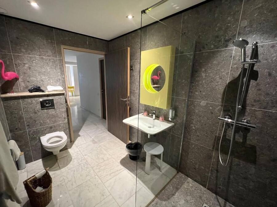 A modern bathroom with a toilet, sink, and shower.