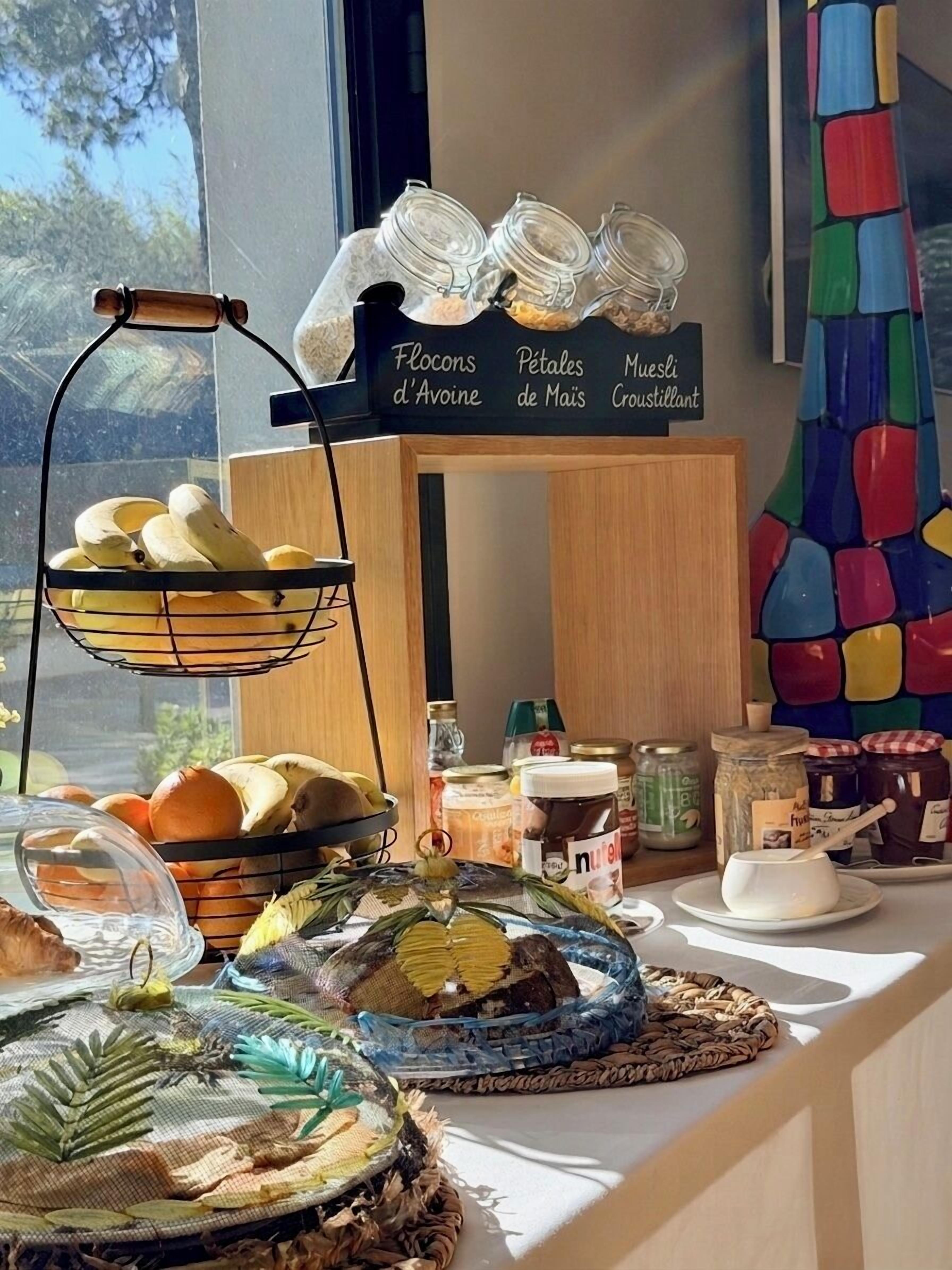 A breakfast buffet with labeled jars of flocons d'avine, petales de maïs, and muesli croustillant.