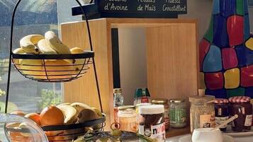 A breakfast buffet with labeled jars of flocons d'avine, petales de maïs, and muesli croustillant.