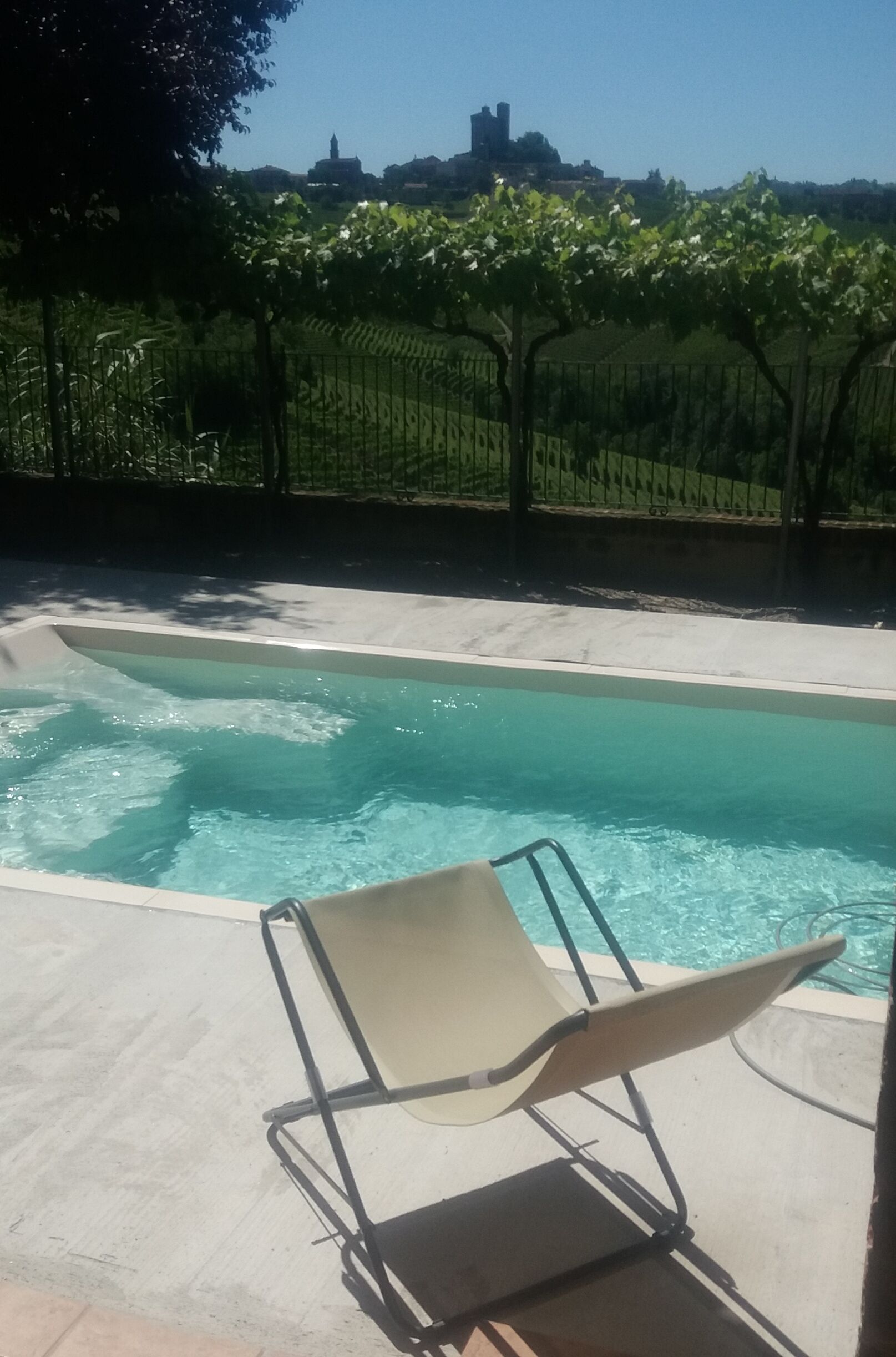 Una piscina al aire libre de temporada, sillones reclinables de piscina