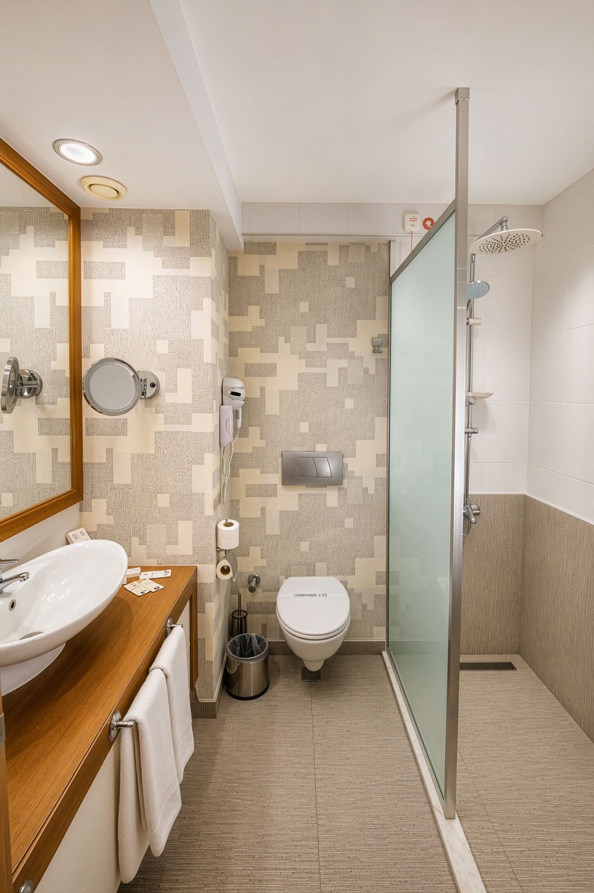 A modern bathroom with a sink, toilet, and shower.