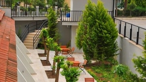 A courtyard with outdoor seating, a staircase, and surrounding greenery. - The Park Marmaris Hotel (Marmaris)