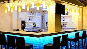 A bar area with a counter, shelves with bottles, and bar stools. - The Park Marmaris Hotel (Marmaris)