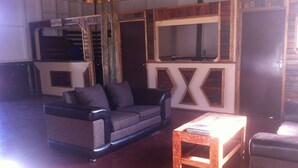 Una habitación con sofá, una mesa de centro de madera y un mueble de madera.