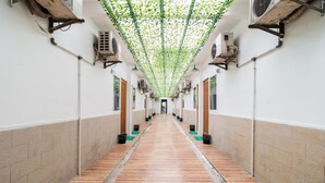 Un pasillo con suelo de madera, paredes blancas y unidades de aire acondicionado en las paredes.