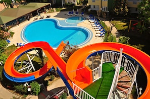 A swimming pool with a water slide and lounge chairs. - Melissa Garden Apart Hotel (Manavgat)