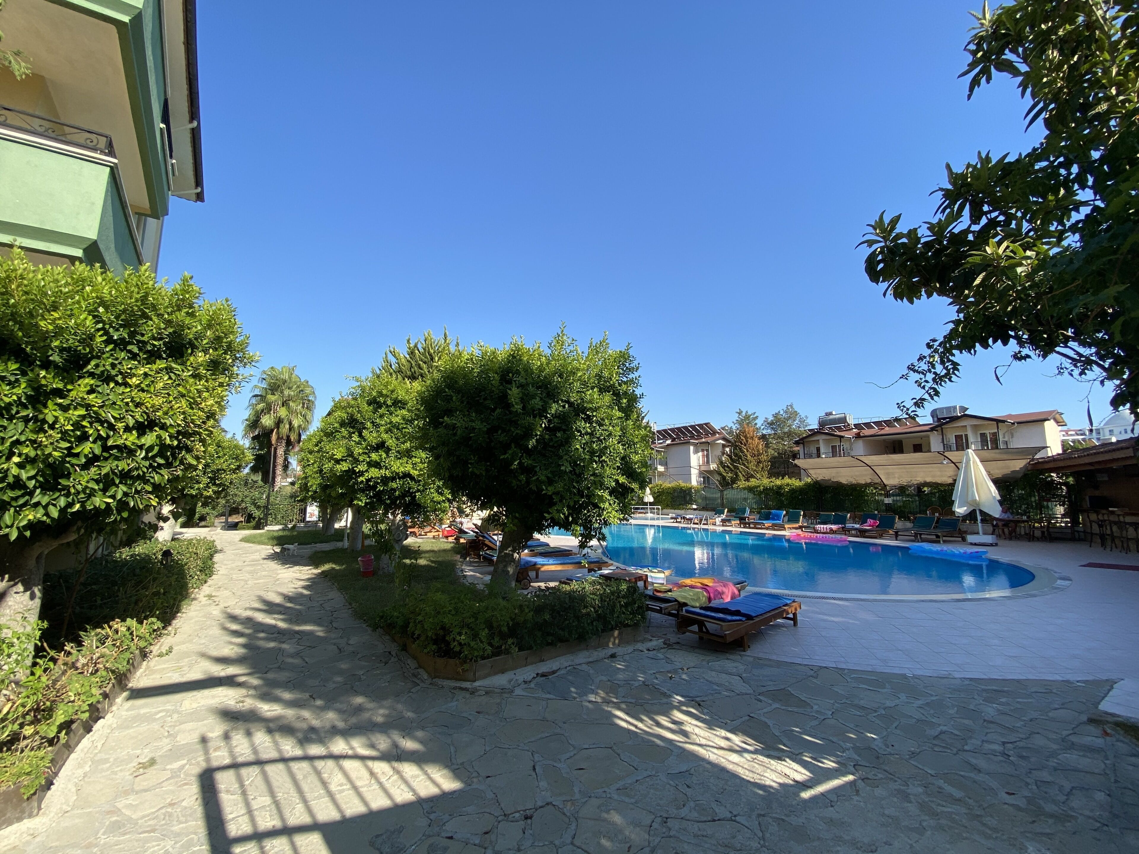 Ein Poolbereich mit Liegestühlen und einem Steinweg.