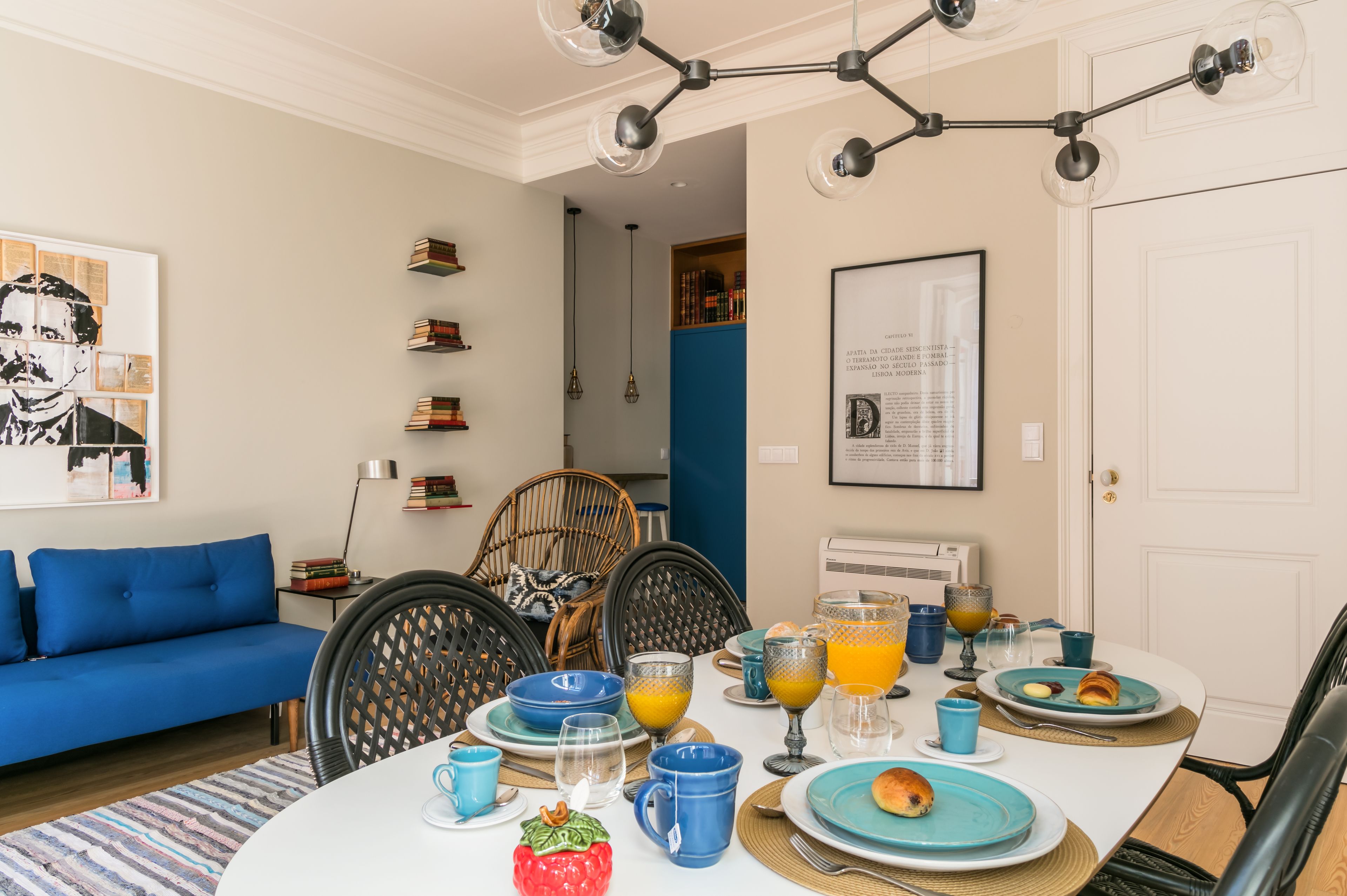 A dining area with a round table set for breakfast, featuring plates, cups, and glasses.