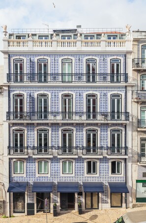 A multi-story building with blue and white patterned tiles, multiple balconies, and awnings over the ground-floor windows. - Almaria Ex Libris Chiado (Lisbon)