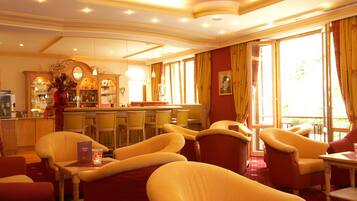 Eine Hotelhalle mit Bar, Sitzgelegenheiten und großen Fenstern.