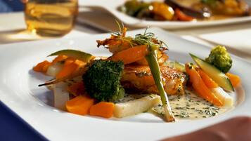 Ein Teller mit Lachs, Gemüse und Soße.