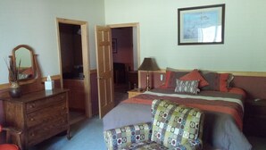 A bedroom with a bed, a chair, a dresser, and a mirror. There is a door leading to another room. - Meisterhaus Bed & Breakfast (Morristown)