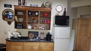 A kitchen with wooden cabinets, a white refrigerator, and various kitchen items on the counter. - Meisterhaus Bed & Breakfast (Morristown)