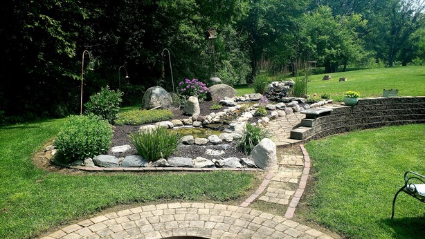 A garden with a stone pathway, a fire pit, and a pond. - Meisterhaus Bed & Breakfast (Morristown)