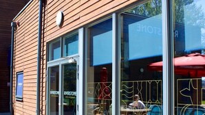 A Riverstone Lodge & Restaurant with large glass windows, outdoor seating, and a wooden facade. - Riverstone Lodge Hotel (Perth)