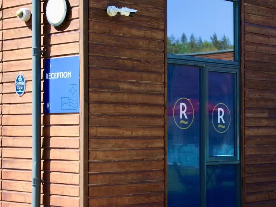 A building with a reception area, a reception sign, and a parking sign.