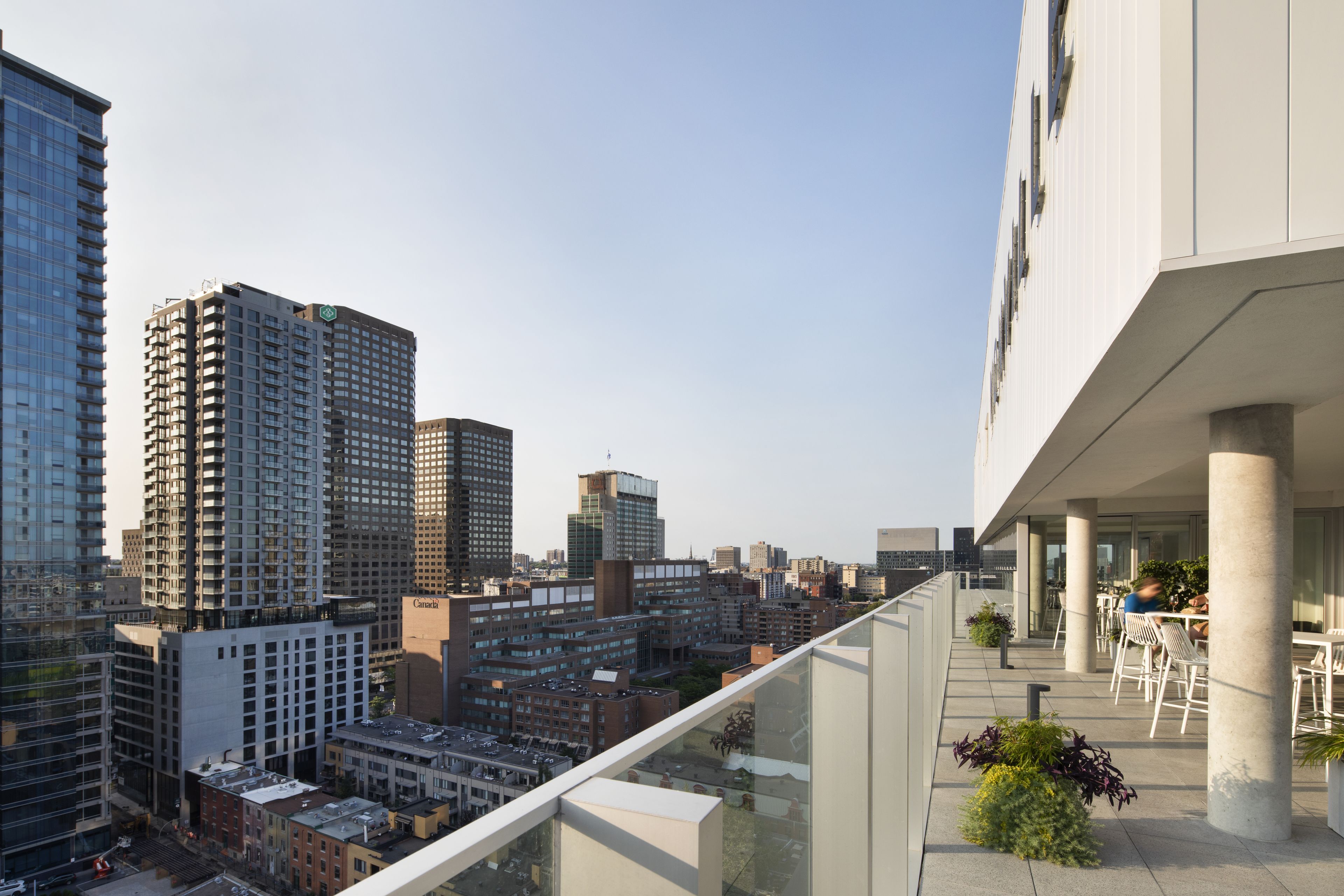 A high-rise building with a glass facade overlooking a cityscape.
