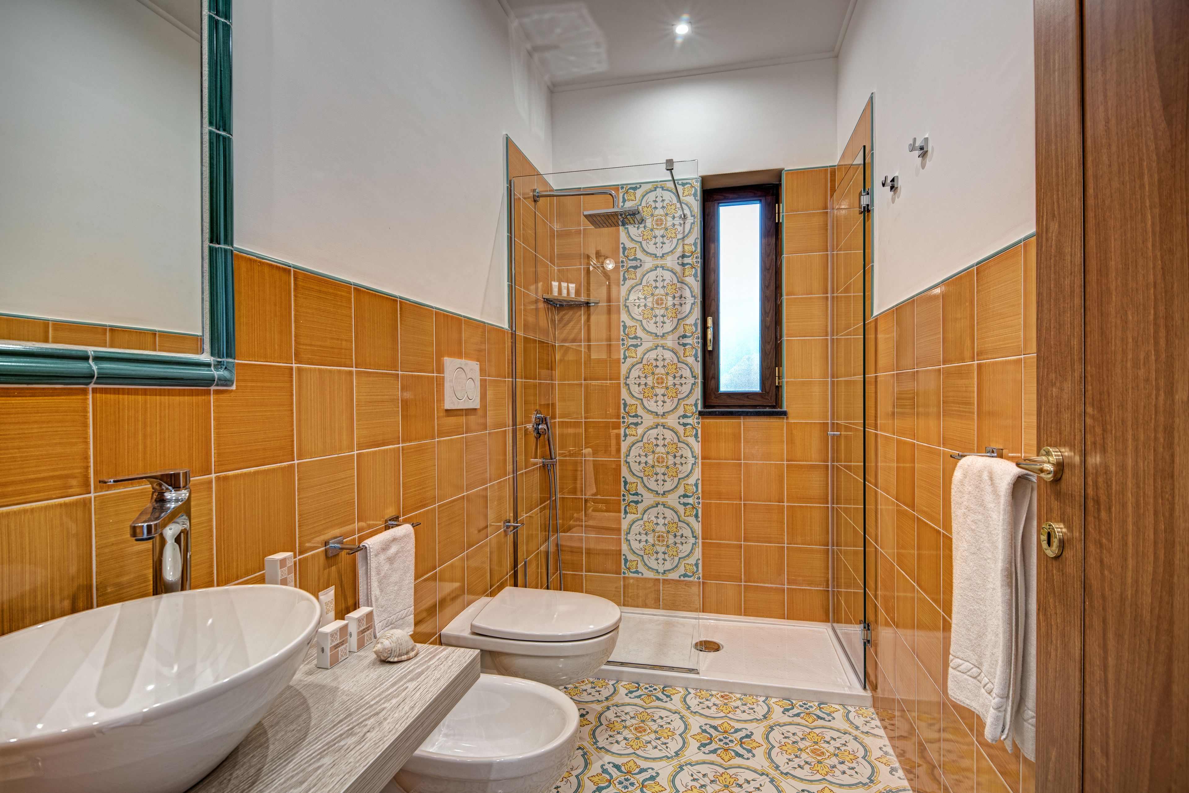 A bathroom with a large sink, toilet, and shower area.
