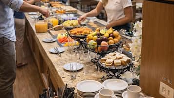 Una mesa de buffet con diversos alimentos y utensilios.