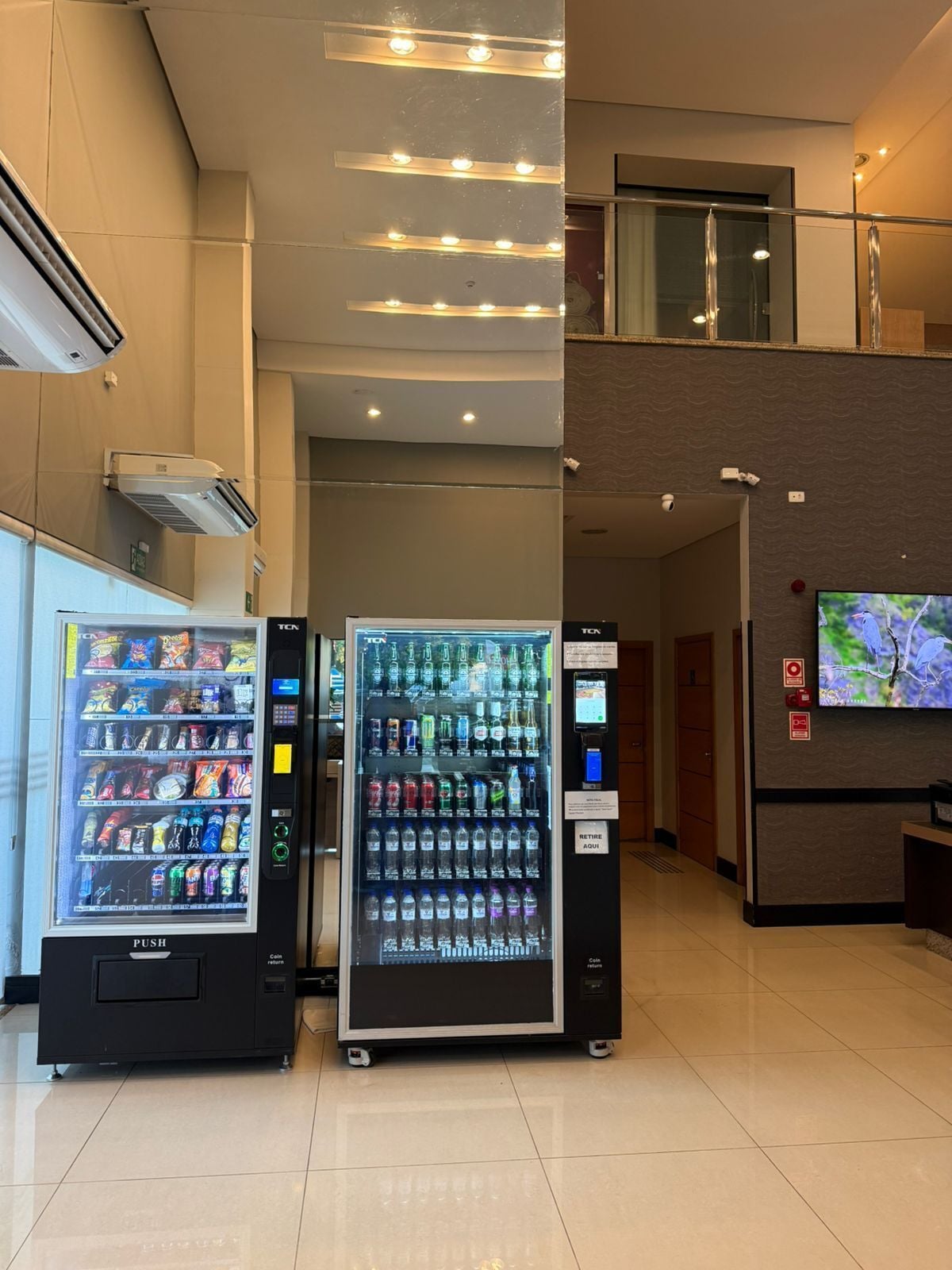 A vending machine area with a TV screen and air conditioning units.