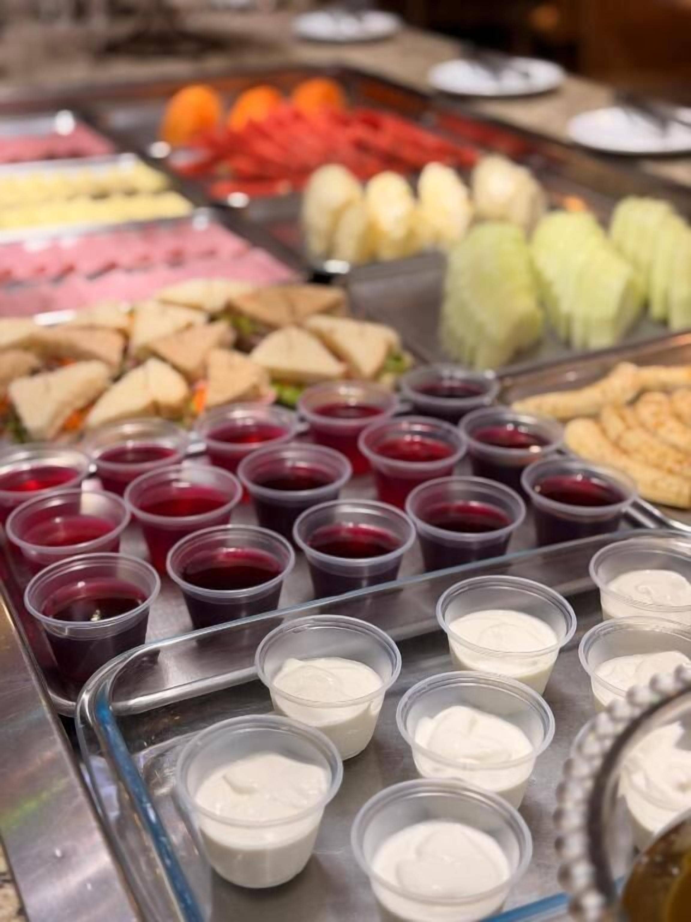 A buffet with various food items and containers of sauces.