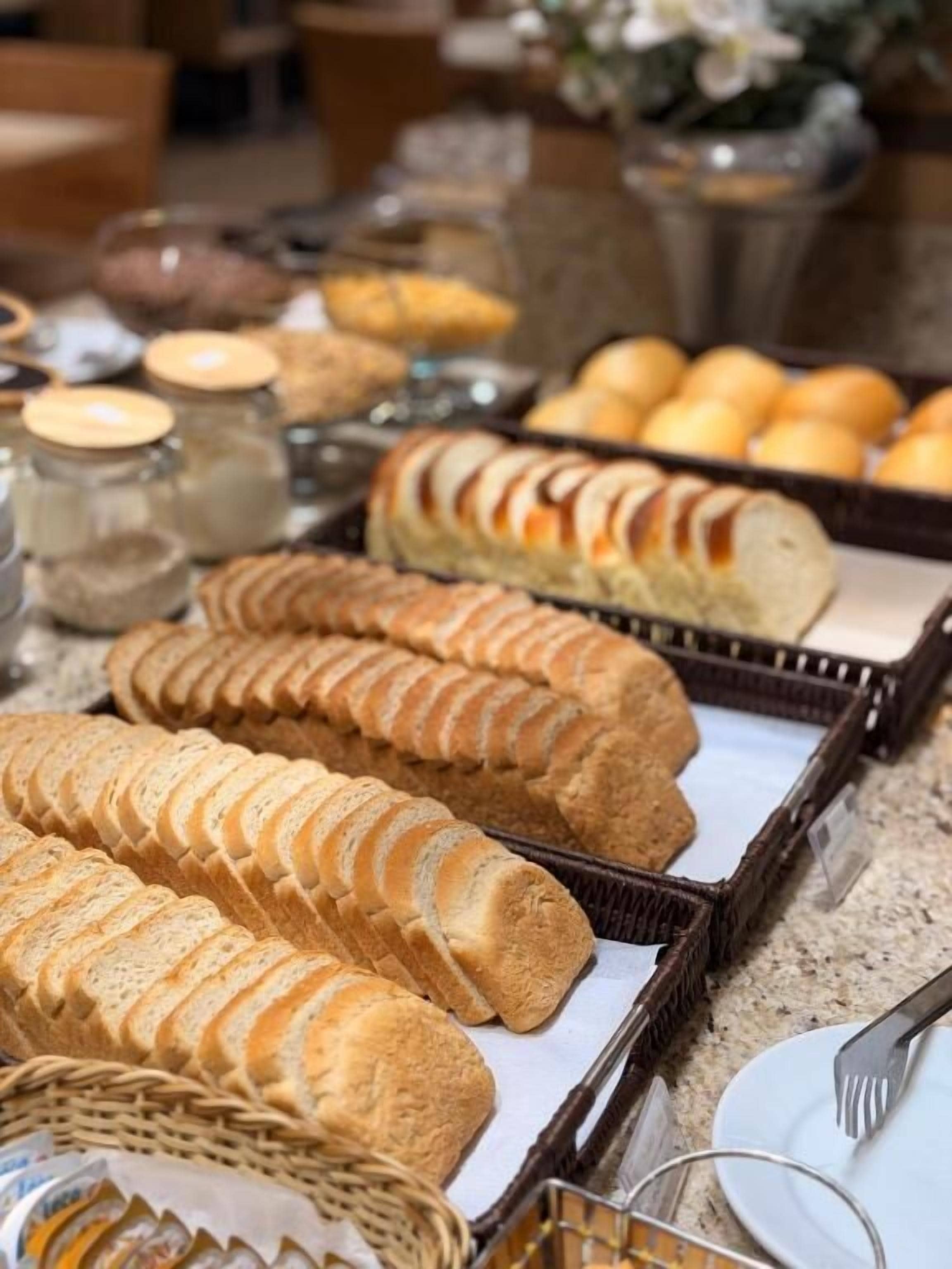 A buffet table with various baked goods, including bread and pastries.
