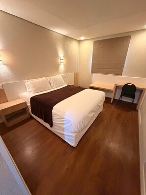 A bedroom with a bed, bedside tables, a desk, and a chair. - Hotel Thomasi Maringa (Maringá)