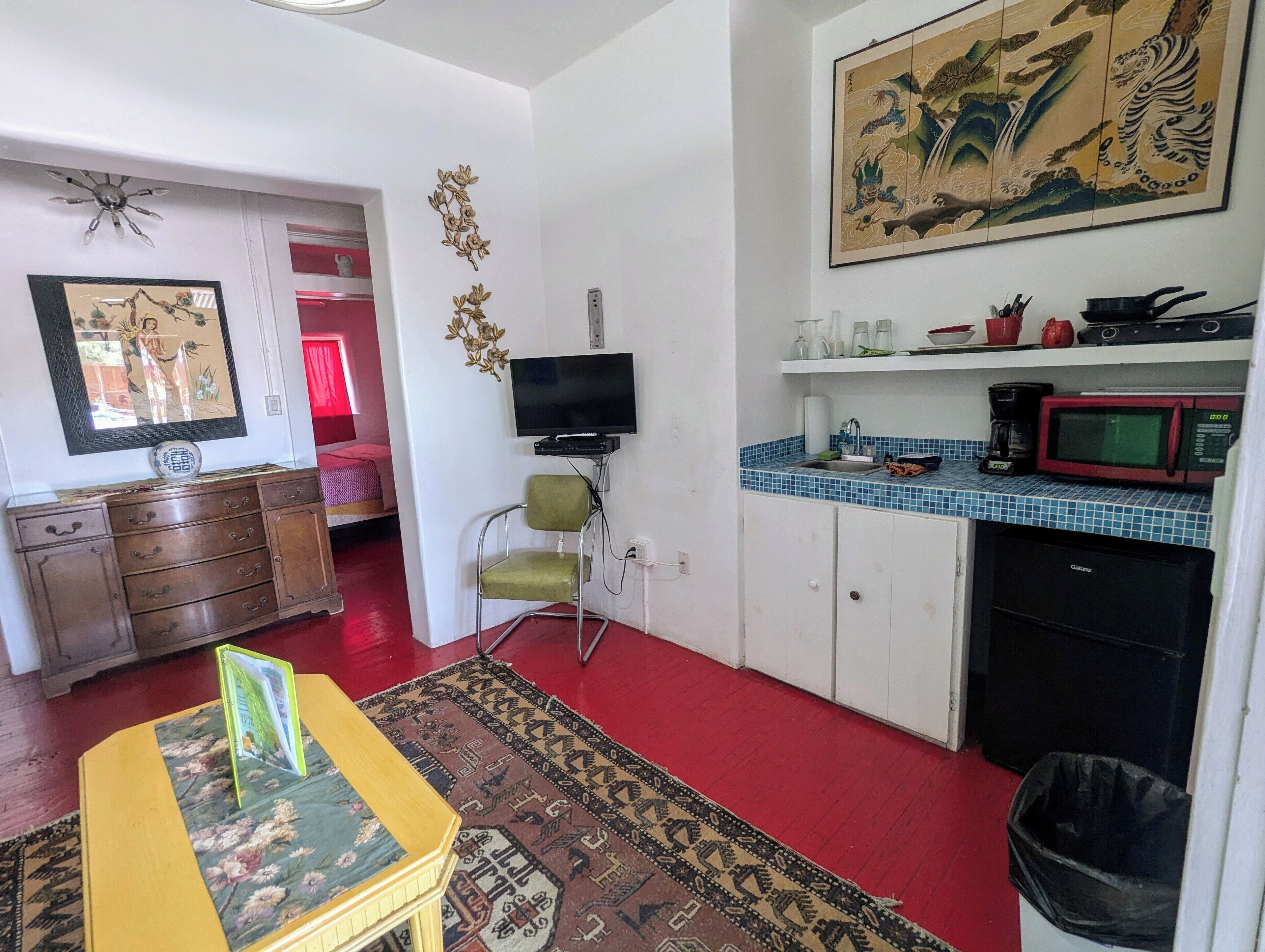 Um espaço compacto com cozinha, sala de jantar e televisão.