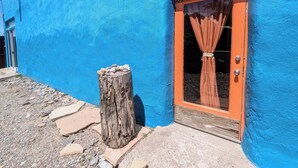 A building with a blue exterior and a wooden door with a curtain.