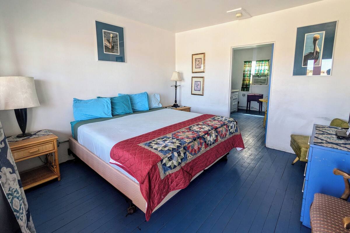 A bedroom with a bed, bedside tables, a desk, and chairs.