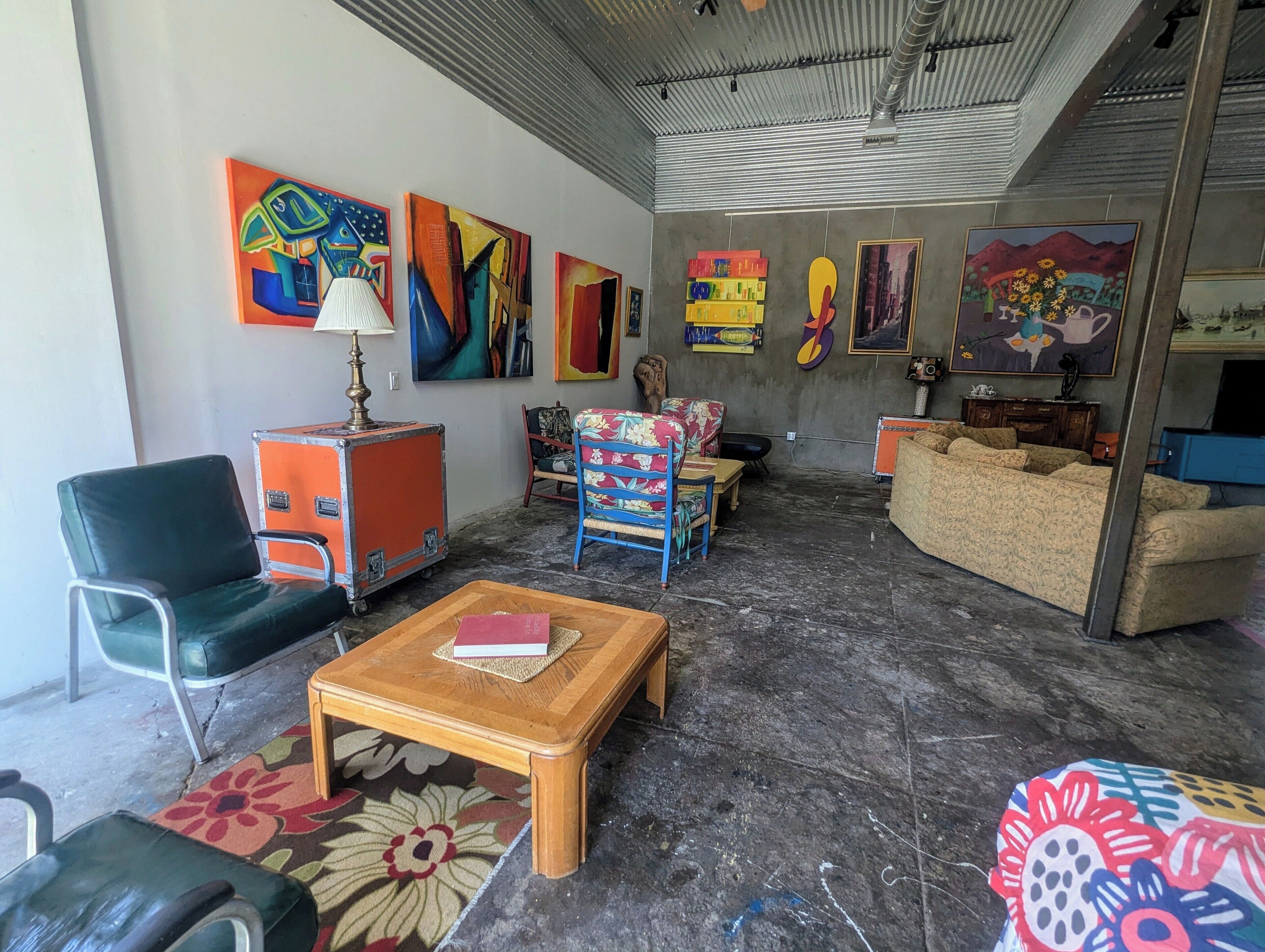 A living room with a sofa, chairs, a coffee table, and artwork on the walls.