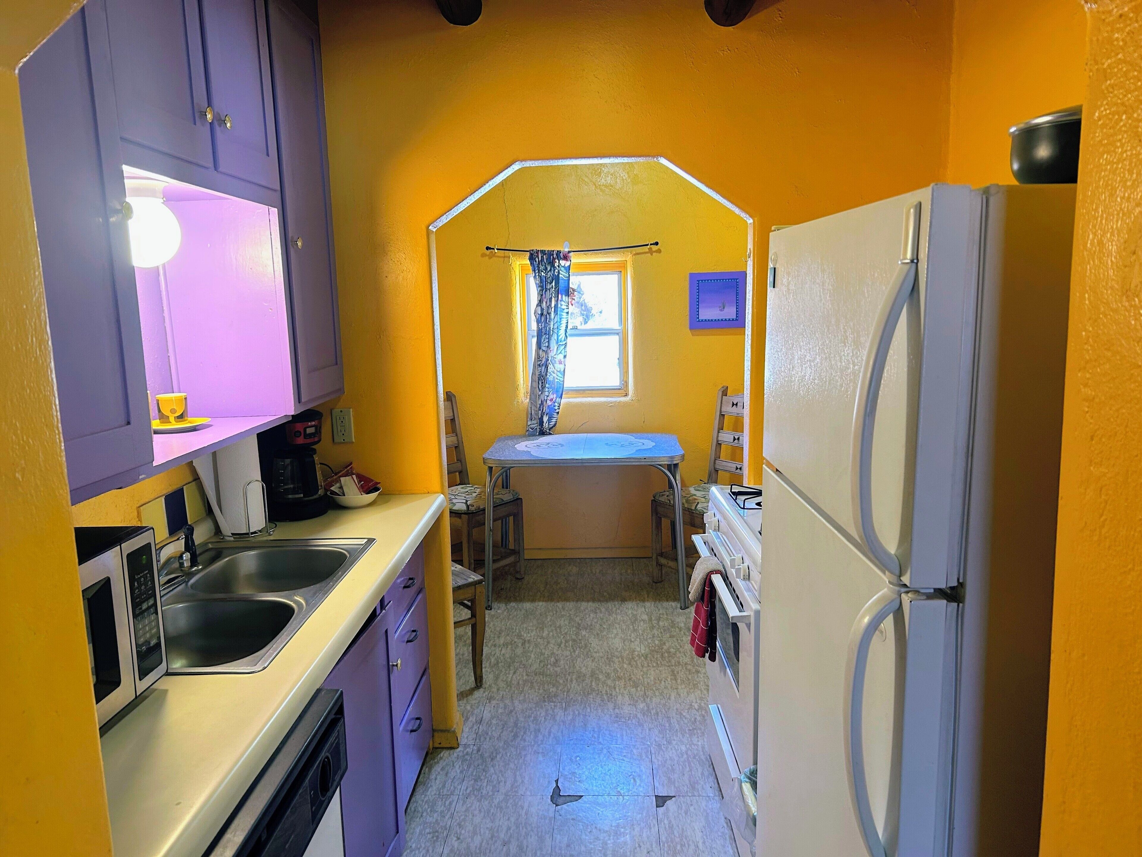 A compact kitchen with a sink, stove, and refrigerator.