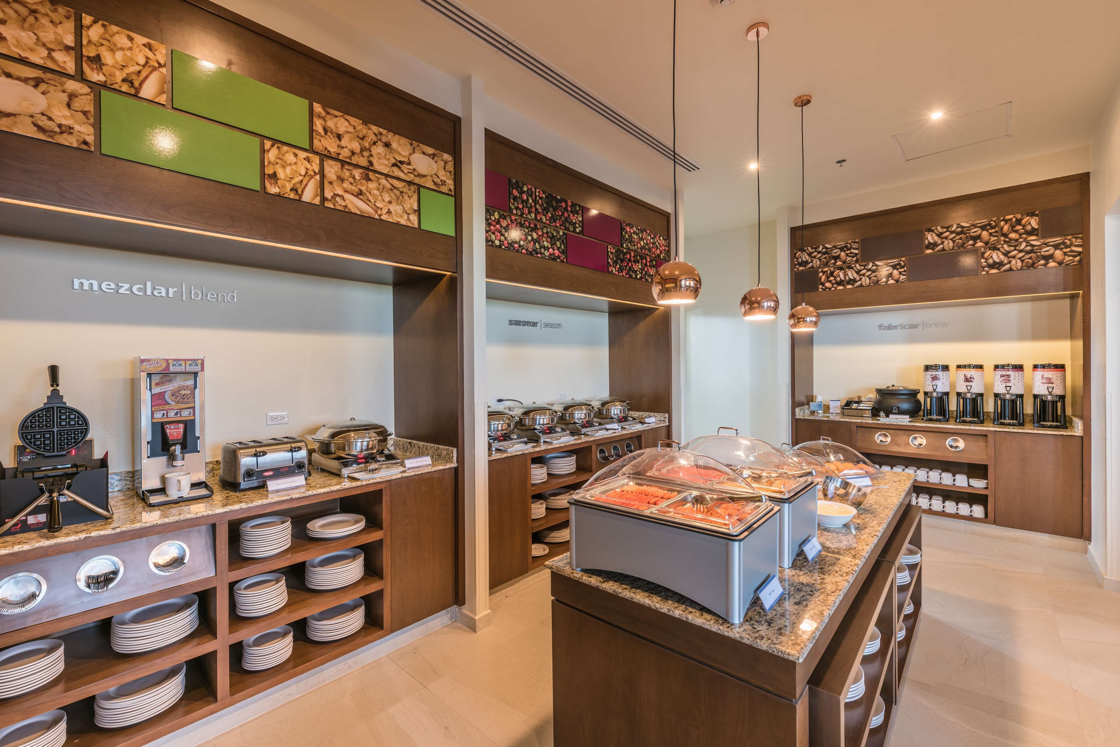 Un espace moderne dédié au petit-déjeuner, équipé d’une machine à café, d’un coin pour préparer le thé et offrant un choix varié d’aliments.