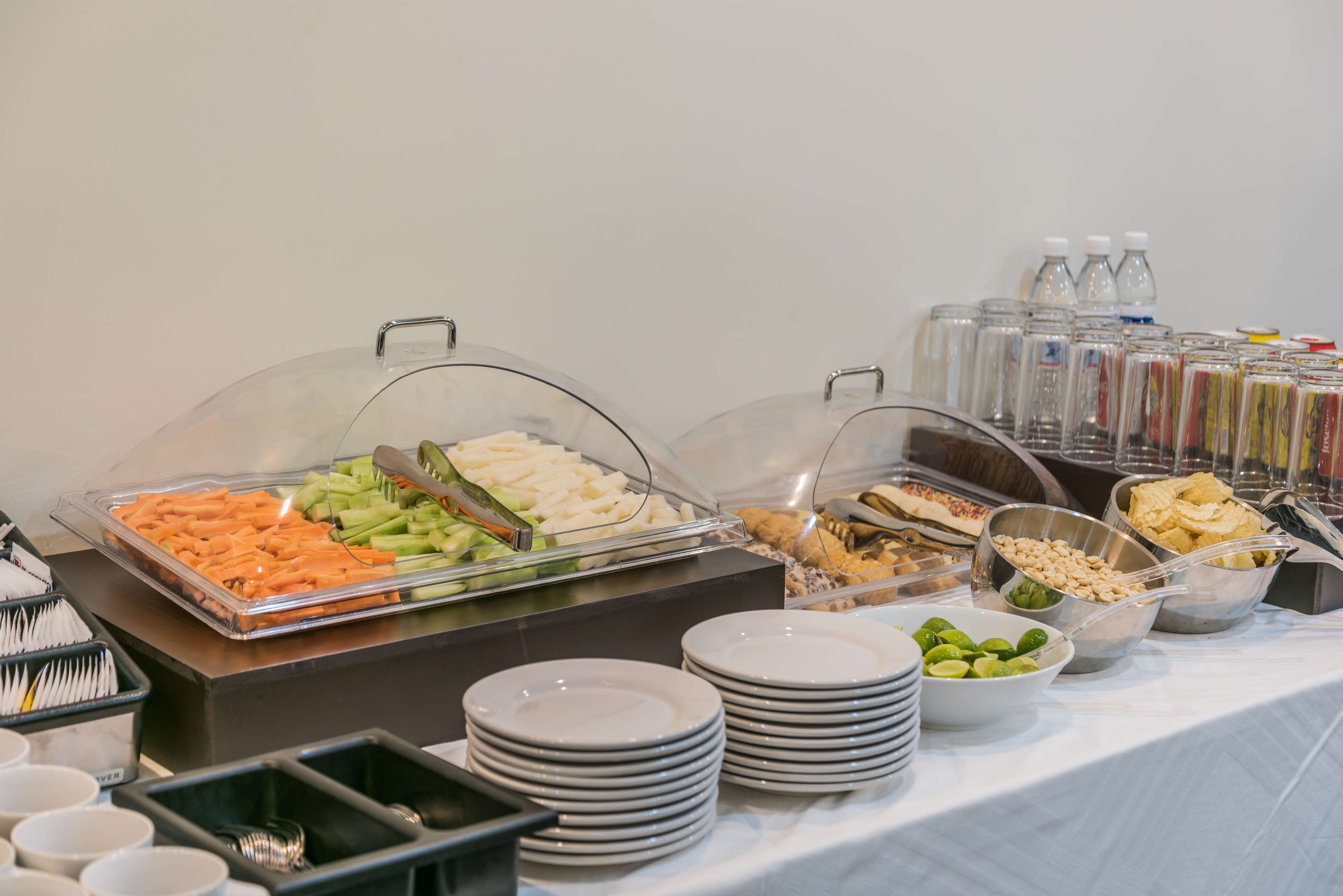 Uma mesa de buffet com diversos alimentos e utensílios.