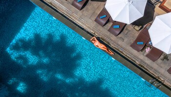 Una piscina al aire libre, sillones reclinables de piscina
