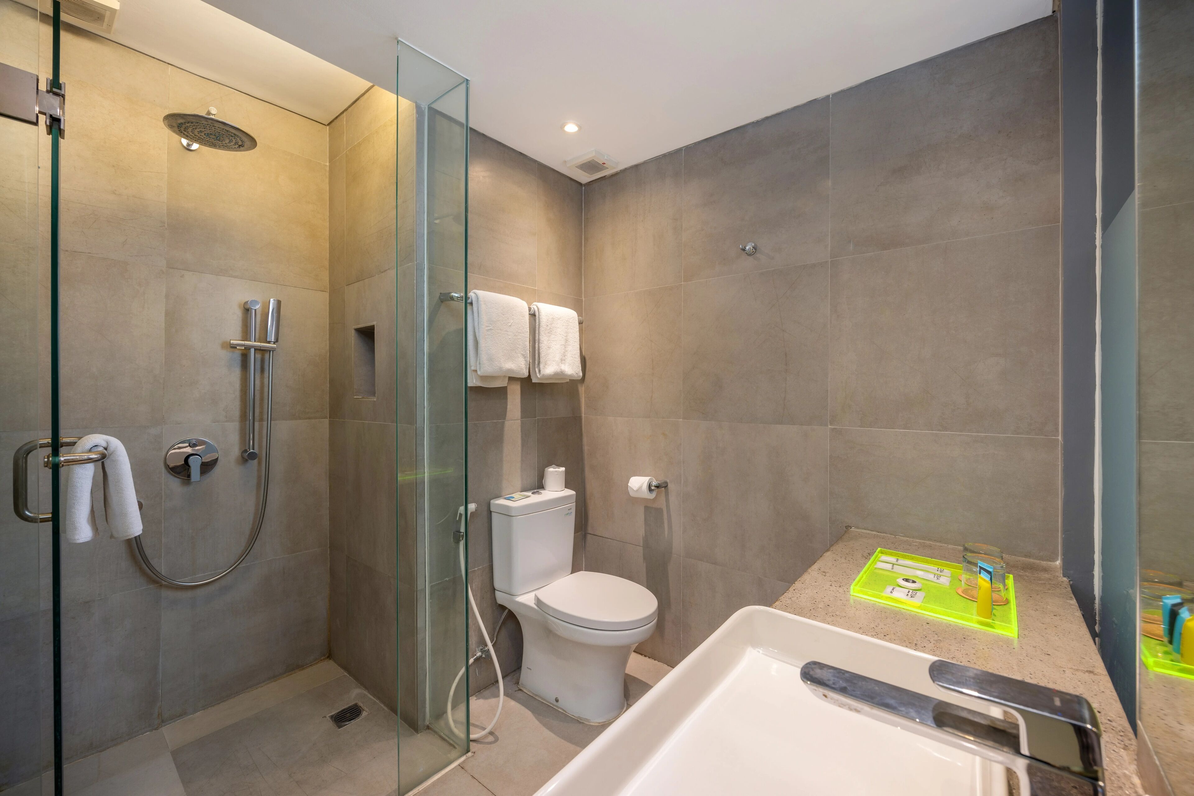 A modern bathroom with a glass-enclosed shower, a toilet, and a bathtub.