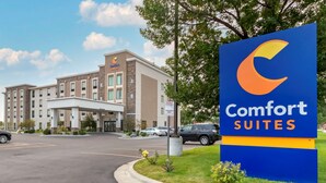 A Comfort Suites hotel with a large sign, a parking lot, and a building with multiple floors and a covered entrance. - Comfort Suites Billings (Billings)