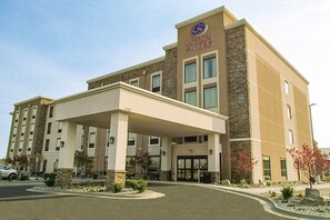 Ein Comfort Suites Hotel mit überdachter Eingangspartei, mehreren Etagen und einer Stein-Fassade.