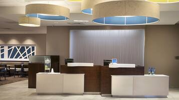 Zona d'entrada amb un disseny modern, que inclou una recepció, zona de seients i un gran finestral.