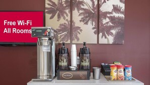 Una estación de café con una cafetera, cápsulas de café y varios recipientes para café.