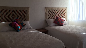A room with two beds, each with a patterned headboard and a colorful pillow. - Casa de la Montaña (San Miguel de Allende)