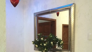A bathroom with a wooden vanity, a potted plant, a mirror, and a telephone. - Casa de la Montaña (San Miguel de Allende)
