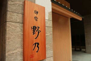 A wooden sign with Chinese characters on a building facade.